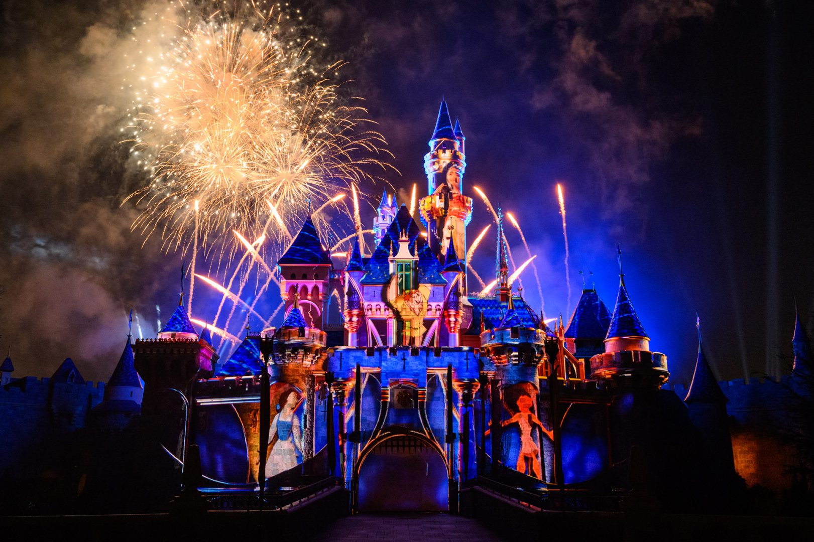 Vista del castillo de Disneyland decorado para el 70º aniversario, con fuegos artificiales iluminando el cielo nocturno. Foto: Disneyland Resort / Disney Parks Blog