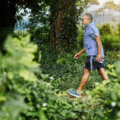 Persona practicando la caminata japonesa en un parque, alternando entre ritmos rápidos y lentos. Foto: Jacob Wackerhausen / Getty Images via Healthline