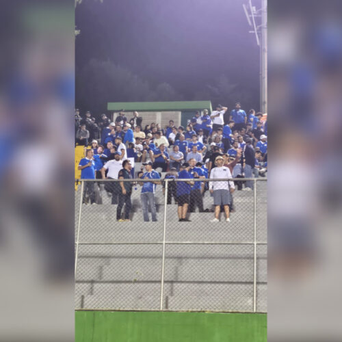 Aficionados salvadoreños, con camisetas azules y blancas, reunidos en las gradas antes del inicio del partido, mostrando su entusiasmo y unidad. Foto: publimetro.sv