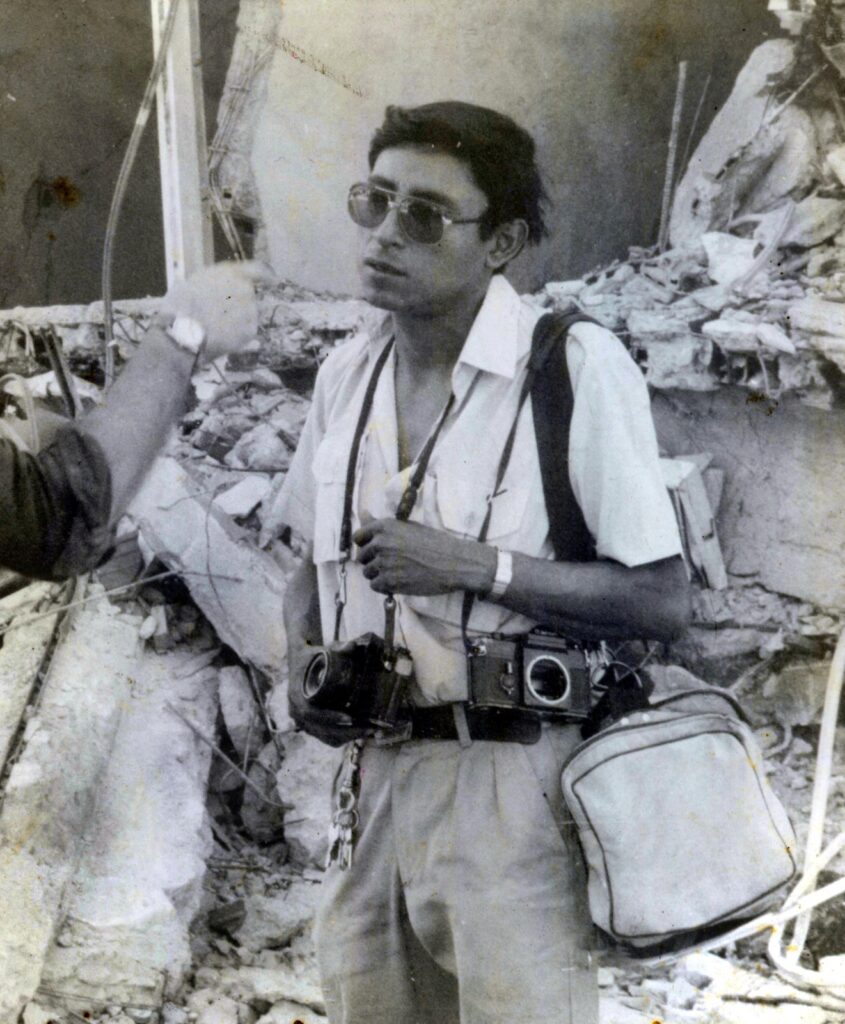 Hoy, en el 39.º aniversario del terremoto de 1986, recordamos no solo la tragedia sino también a quienes la documentaron. El fotoperiodista Francisco Campos es captado aquí en una entrevista, con los restos del emblemático edificio Rubén Darío como mudo testigo de la destrucción.