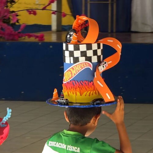 Estudiantes salvadoreños muestran sus sombreros creativos hechos con materiales reciclados durante la actividad "El Sombrero Loco". Foto: Cortesía.