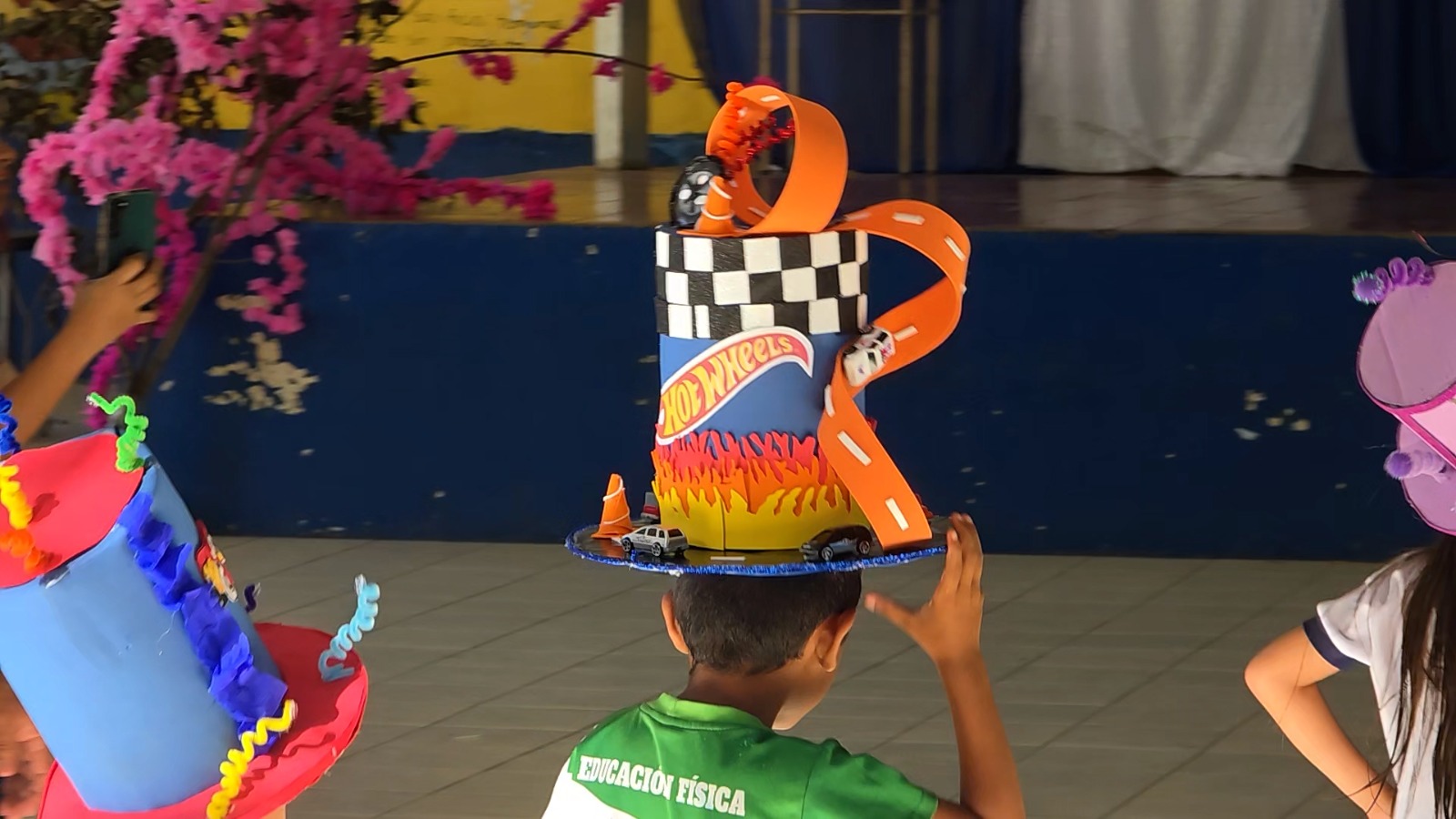 Estudiantes salvadoreños muestran sus sombreros creativos hechos con materiales reciclados durante la actividad "El Sombrero Loco". Foto: Cortesía.