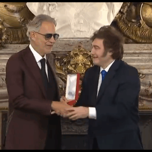 Javier Milei intenta saludar de mano a Andrea Bocelli tras condecorarlo, pero el tenor ciego no ve el gesto y genera risas virales en X. Foto: Cortesía.
