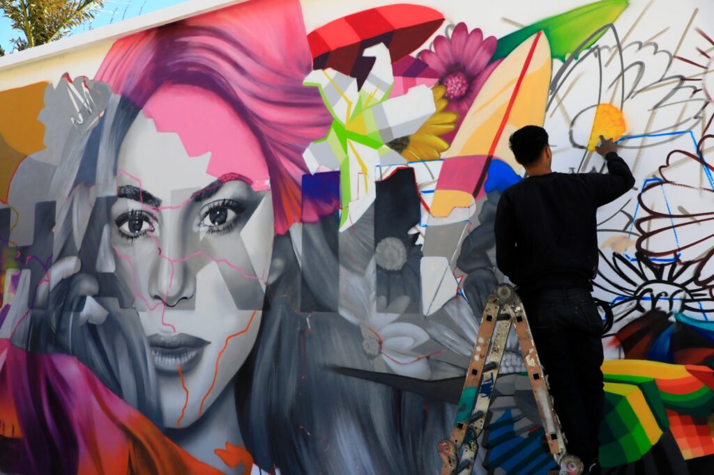 El artista TNT finaliza un mural dedicado a Shakira en el Estadio Mágico González, fusionando la esencia de la cantante con símbolos nacionales. Foto: Cortesía.