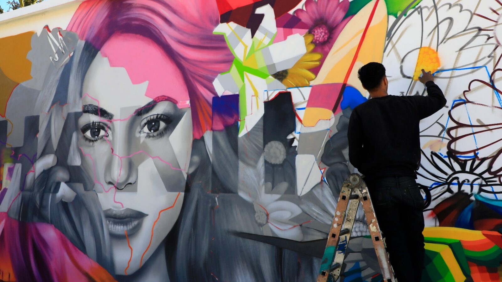 El artista TNT finaliza un mural dedicado a Shakira en el Estadio Mágico González, fusionando la esencia de la cantante con símbolos nacionales. Foto: Cortesía.