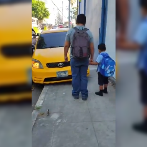 Un video viral muestra a un sedán amarillo invadiendo la acera frente a la PNC, obligando a un niño y su padre a apartarse. El Viceministerio de Transporte analiza sanciones por conducción temeraria. Foto: @SivarNewsSV.