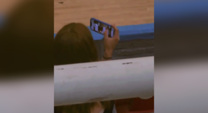 Un video captó a una joven en #ElSalvador simulando grabar un partido de básquetbol mientras revisaba el WhatsApp de su pareja. ¡Tendencia total en redes! Foto: Cortesía.