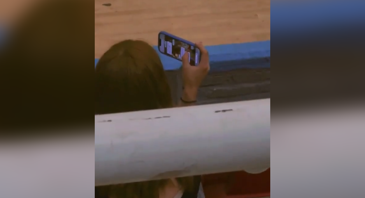 Un video captó a una joven en #ElSalvador simulando grabar un partido de básquetbol mientras revisaba el WhatsApp de su pareja. ¡Tendencia total en redes! Foto: Cortesía.