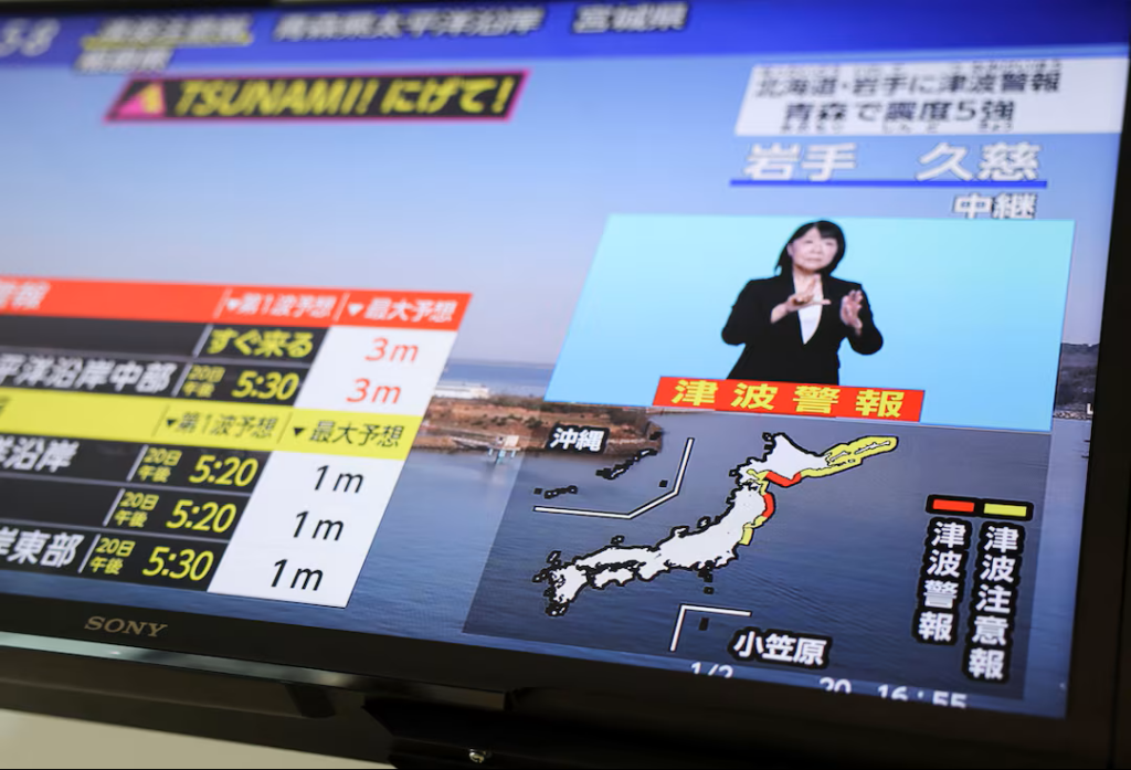 A television screen displays a news report about a tsunami warning issued by the Japan Meteorological Agency, stating that waves up to 3 meters high could impact extensive coastal areas in the north of the country, following a preliminary magnitude 7.4 earthquake off the northeast coast. The scene was captured in Tokyo, Japan, on April 20, 2026. Photo: REUTERS/Issei Kato.