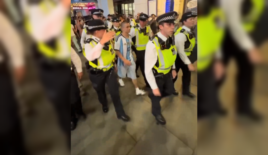 Agentes británicos formaron un cordón de seguridad para escoltar a un hincha argentino rodeado por fanáticos rivales en el centro de Londres. El incidente ocurrió tras la eliminación de Inglaterra en el Mundial 2026. Foto: Captura de pantalla