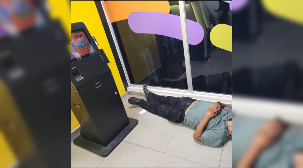 Un hombre se durmió en el cajero del Banco Agrícola para escapar del calor extremo en El Salvador. Las redes lo celebraron como el "Rey del Cajero Acondicionado". Foto: @SivarNewsSV.