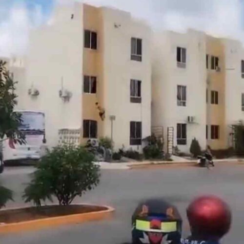 Un hombre semidesnudo quedó suspendido de una ventana en un edificio de Cancún antes de sufrir una aparatosa caída el 12 de octubre de 2026. Captura de pantalla
