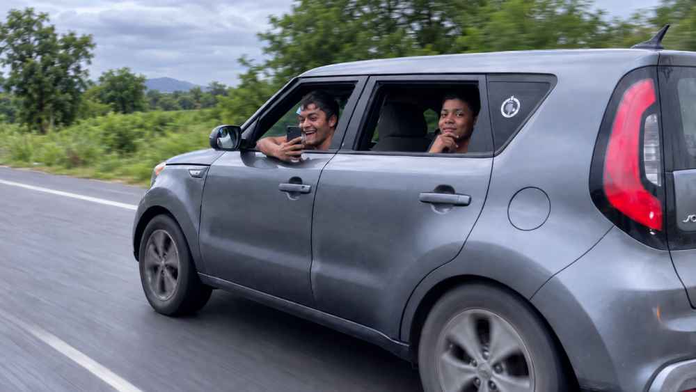 Conductor de un Kia Soul aparece con un celular en la mano durante una grabación difundida en redes sociales. Captura: Ilustración.